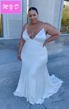 a woman in a white dress posing for the camera with her hands on her hips