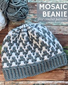 a crocheted beanie sitting on top of a wooden table next to balls of yarn