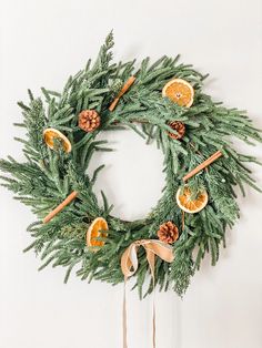 a christmas wreath with oranges and pine cones