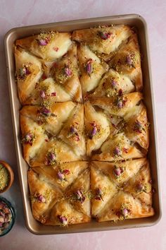 a pan filled with lots of food next to bowls