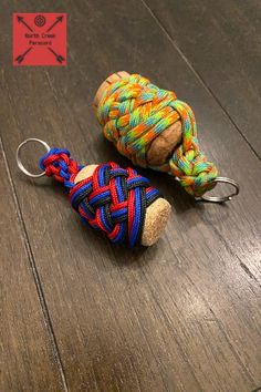 two small items on a wooden floor with a red, blue and yellow rope wrapped around them