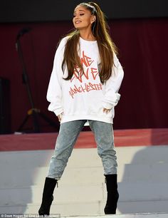 a young woman riding a skateboard on top of a cement slab in front of a stage