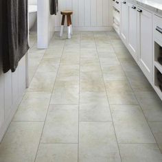 a kitchen with white cabinets and tile flooring