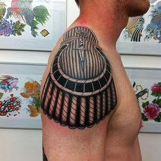 a man with a tattoo on his shoulder and chest has a birdcage in it