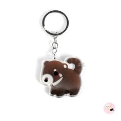 a brown and white bear keychain with a black rubber ring on it's side