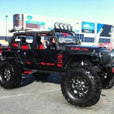 a black jeep is parked in a parking lot