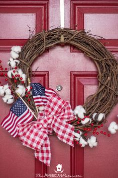 a red door with a wreath on it and the words diy farmhouse flag wreath