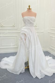 a white wedding dress on display in a room