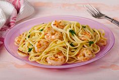 a plate of pasta with shrimp and parsley on the side next to a fork