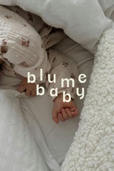 a baby is sleeping under a blanket with the words blume baby written on it