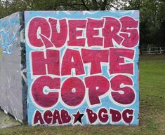 a sign that says queens hate cops acab b c d g e on the side of a building