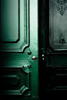 the door is green and has ornate designs on it