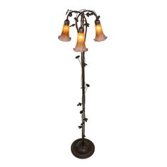 a floor lamp with three lights on it and flowers hanging off the side of it