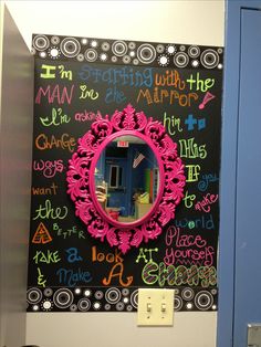 a bathroom with a blue door and a chalkboard on the wall behind it that says man in the mirror