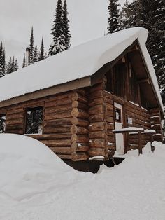 a log cabin with snow on the roof