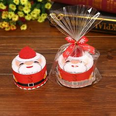 two small red and white christmas decorations on a wooden table