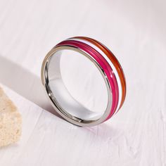 Beautifully polished stainless steel ring, with vibrant enamel stripes encircling the entire band, in the colors of the inclusive "sunset" Lesbian pride flag. This ring is perfect for your wedding, anniversary, pride event, or just because! Buy one for a friend or loved one, and one for you too! Stainless Steel 6 mm wide band Not sure of your size? Click here to view our Ring Size Guide including an easy way to measure your own finger for accurate sizing. Our rings are in U.S. sizing. Click here Lesbian Rings, Lesbian Accessories, Lesbian Ring, Pride Rings, Queer Clothes, Pride Event, Lgbtq Quotes, Lesbian Pride Flag, Pride Jewellery