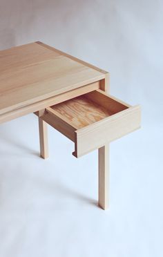 a small wooden table with two drawers on each side and an open drawer in the middle