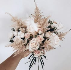 a bouquet of flowers is being held up by someone's hand on a white background