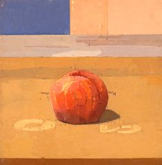 an apple sitting on the ground in front of a building with blue and yellow walls