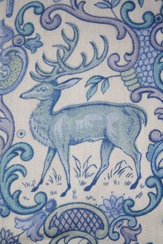 an image of a deer on a blue and white wallpaper pattern with flowers, vines, and swirls