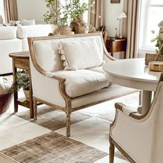 a living room filled with white furniture and lots of pillows on top of it's couches