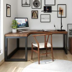 a desk with a computer and many pictures on the wall above it, along with a chair