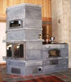 an outdoor oven made out of concrete blocks in a kitchen with wood paneling on the walls