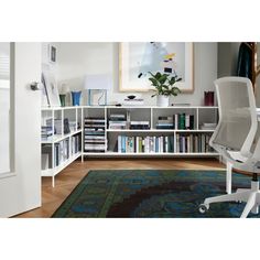 a white chair sitting in front of a book shelf filled with books