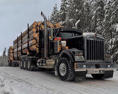 a large truck hauling logs down a snow covered road