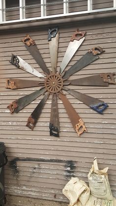 a large clock made out of old tools on the side of a building