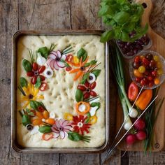 a pan filled with food sitting on top of a wooden table next to other foods