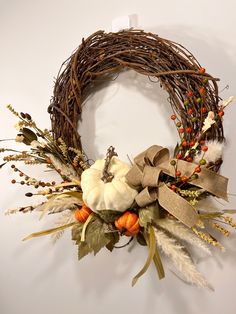 a wreath with white pumpkins and autumn leaves