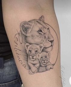 a woman's thigh with a lion and cub tattoo on it