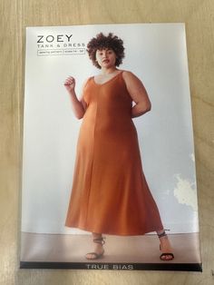 a woman in an orange dress standing on a wooden table