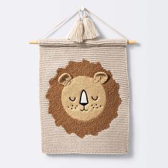 a crocheted wall hanging with a lion face on it's front and back