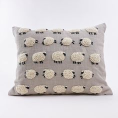 a grey pillow with black and white sheep on it