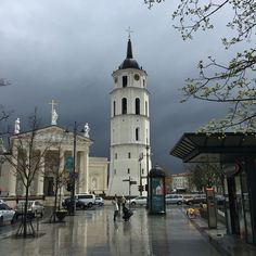 a large white building with a clock on it's side in the middle of a city