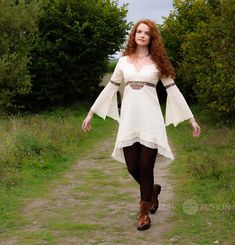 Luna Lace Dress  100% cotton lace dress embroidered with Celtic knot work. Colour - White This dress features a fanned bell sleeve and high low skirt design.  Celtic knotwork is always cyclical and never-ending. In this way, we have chosen to use Celtic knotwork in our designs as a symbol for the endurance of the ancient culture where they originated. Through our designs, we hope to help continue the ideas that Celtic culture symbolises. Using knotwork not only helps to keep that ancient form of Bohemian Dresses For Larp, Cotton Dresses For Larp, Fitted White Boho Dress With Lace Trim, Bohemian Cotton Crochet Dress With Lace Trim, White Cotton Crochet Dress, Bohemian Crochet Cotton Dress With Lace Trim, Festival Long Sleeve Lace Dress, Summer Gothic Cotton Dress, Cotton V-neck Dress With Lace Patchwork