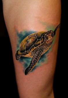 a tattoo on the leg of a woman with a sea turtle