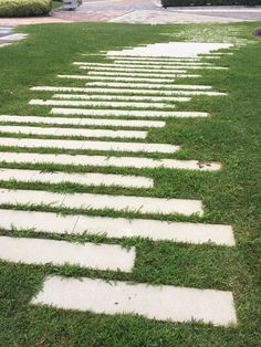 stepping stones in the grass on a sidewalk