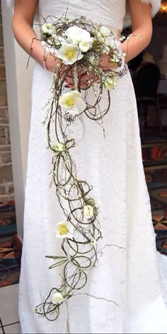 a woman in a white dress holding a bouquet of flowers