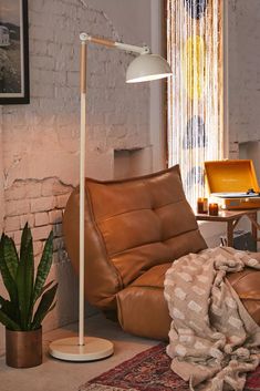 a living room filled with lots of furniture and a large potted plant in the corner