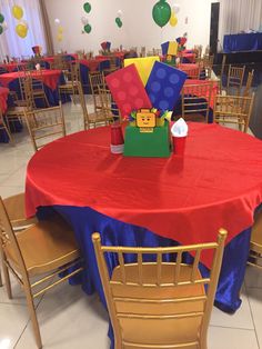 a red table topped with a green box filled with lego blocks and other items sitting on top of it