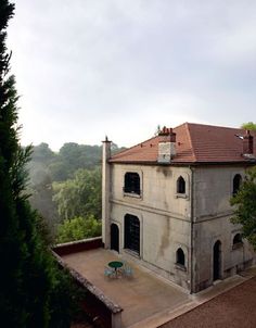 an old building with a red roof surrounded by trees