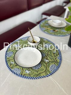 two plates with spoons on them sitting on a table