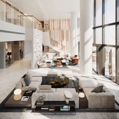 a living room filled with lots of furniture next to tall glass windows on the wall