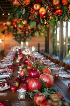 the long table is set with apples and silverware for an elegant fall wedding reception