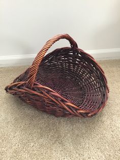 a wicker basket sitting on the floor in front of a white wall and carpet