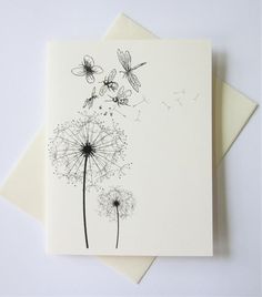 a card with a dandelion and butterflies on it, sitting on top of a white envelope